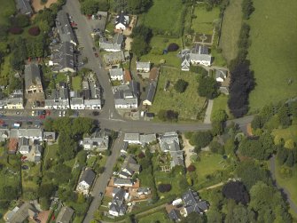 General oblique aerial view of the village centred on the churches, burial-ground and manse, taken from the SSE.