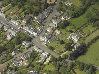 General oblique aerial view of the village centred on the churches, burial-ground and manse, taken from the SE.