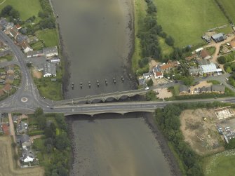 Oblique aerial view centred on the old bridge, rail bridge and new road bridge, taken from the SSE.