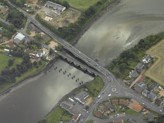 Oblique aerial view centred on the old bridge, rail bridge and new road bridge, taken from the NW.