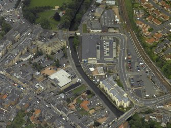 Oblique aerial view centred on the footbridge and railway station, taken from the NE.