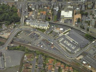 Oblique aerial view centred on footbridge and railway station, taken from the NW.