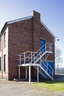 View showing gable end with fire escape stairs of barrack block from the E.