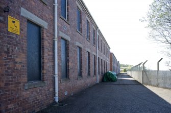 Detail.  Showing N-facing elevation of barrack blocks with perimeter fence on right.