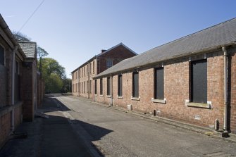 View of barrack block with store hut from E.