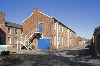 View showing S-facing barrack blocks with store huts on right from WSW.