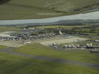 Oblique aerial view centred on the airport terminal and control tower, taken from the NW.