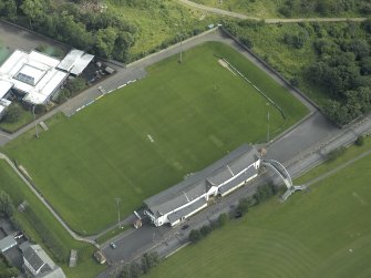 Oblique aerial view centred on rugby ground, taken from the NW.