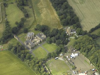 Oblique aerial view centred on the country house with the Collegiate Chapel adjacent, taken from the S.