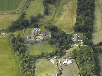 Oblique aerial view centred on the country house with the Collegiate Chapel adjacent, taken from the SE.