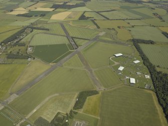 Oblique aerial view centred on the airfield with the Museum of Flight adjacent, taken from the W.