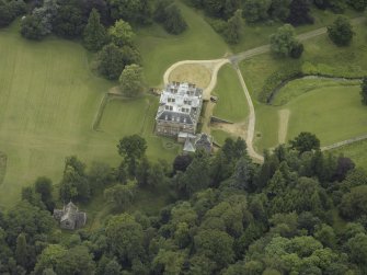 Oblique aerial view centred on the country house with the burial vault adjacent, taken from the E.