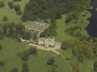 Oblique aerial view centred on the country house and stables, taken from the S.