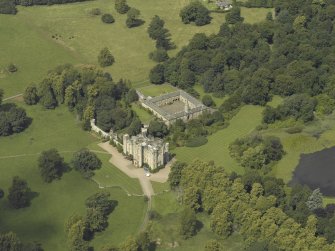 Oblique aerial view centred on the country house and stables, taken from the SSE.