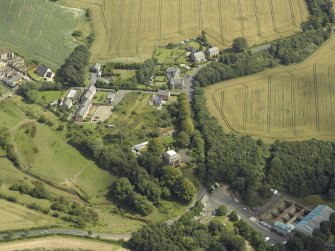 Oblique aerial view centred on the house with the paper mill filter beds adjacent, taken from the SW.