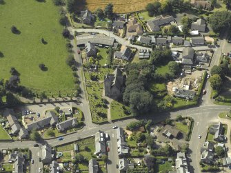 Oblique aerial view of Newtyle village centred on the Church, taken from the NE.
