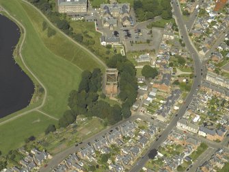 Oblique aerial view centred on the water tower with the high school adjacent, taken from the S.
