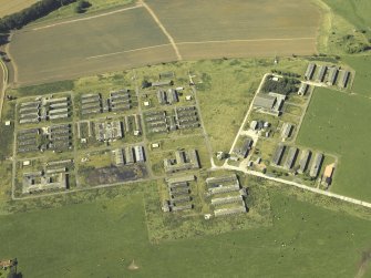 Oblique aerial view centred on the accommodation camp, taken from the SE.