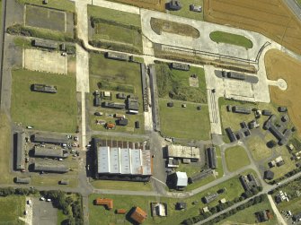 Oblique aerial view centred on the technical area with the control tower adjacent, taken from the NNE.