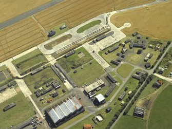 Oblique aerial view centred on the technical area with the control tower adjacent, taken from the N.