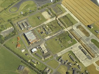 Oblique aerial view centred on the technical area with the control tower adjacent, taken from the W.