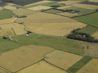 Oblique aerial view centred on grass airfield  with the farmstead adjacent, taken from the NW.
