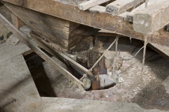 Interior. First floor. Detail of 'Damsel ' or grain feed apparatus and the hopper as it feeds grain into the grinding stones.