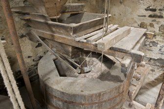 Interior. First floor. Detail of 'Damsel ' or grain feed apparatus and the hopper as it feeds grain into the grinding stones.