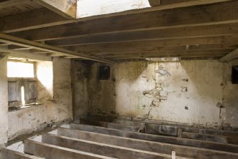 Interior. First floor, storage area from milling floor . Note sack hoist frame in floor joists and shute openings into the kiln floor.