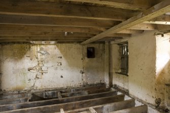 Interior. First floor. Storage area from milling floor . Note sack hoist frame in floor joists and shute openings into the kiln floor.