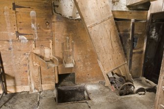 Interior. Ground floor. Winnower, fanner. This blows the chaff from grain that has passed through the shelling stones on the first floor.