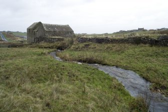 View of mill building , lade and stream from mill pond in foreground.