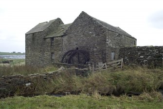 View of NW elevation of mill building with waterwheel frame.