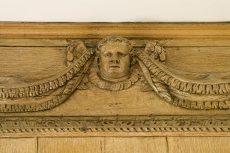 Interior.  Detail of carved wooden head on panelling in Ante-Room.