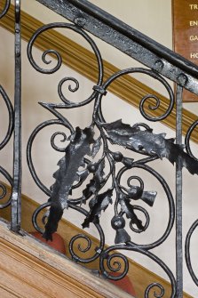 Interior.  Detail of staircase balustrade, thistle and oak motif.