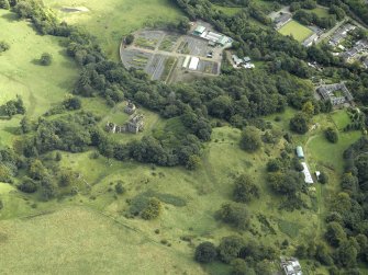 Oblique aerial view centred on the house and walled garden with the earthwork adjacent, taken from the NW.