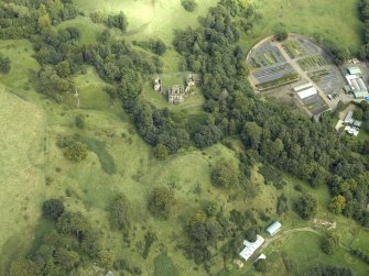 Oblique aerial view centred on the house and walled garden with the earthwork adjacent, taken from the SW.