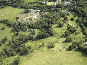 Oblique aerial view centred on the house and walled garden with the earthwork adjacent, taken from the NNW.