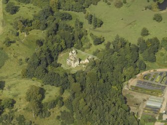 Oblique aerial view centred on the house and walled garden with the earthwork adjacent, taken from the SSW.