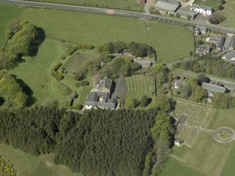 Oblique aerial view centred on Glebe house with the church adjacent, taken from the SE.