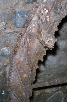 Interior. Detail of inside surface of wheel shroud. Note the cast slots in the wheel rim ,which held the wooden buckets, and the rim gear.The remains of the drum boards are visible.