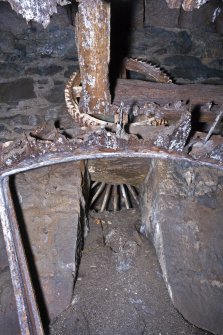 Interior. View looking up below rim spur gear with small driven gear above. This suggests that a threshing machine was driven by this wheel and its trnsmiision via the flat belt pulley wheel just visible.
