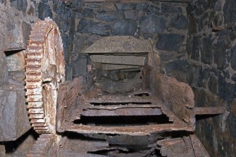 Interior. View looking along remains of wooden launder, small driven gear to left of image.