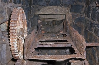 Interior. View looking along remains of wooden launder, small driven gear to left of image.