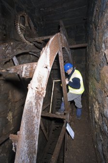 Interior. Waterwheel pit. View of J Borland of RCAHMS undertaking graphic survey.