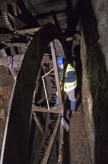 Interior. Waterwheel pit. View of J Borland of RCAHMS undertaking graphic survey.