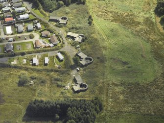 Oblique aerial view centred on the postwar anti-aircraft battery gun emplacements with the WW II radar ramp adjacent, taken from the NW.