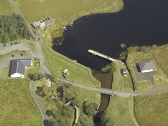 Oblique aerial view centred on the dam and sluice with bridge adjacent, taken from the W.