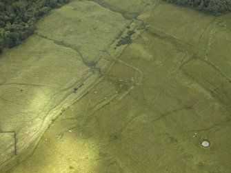 Oblique aerial view centred on the decoy site with a bomb crater adjacent, taken from the N.