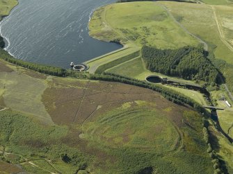 Oblique aerial view centred on the remains of the fort with the dam and reservoir adjacent, taken from the E.